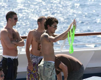 John Mayer displaying his soon to be worn Brigitewear Borat thong swimsuit to his shipboard fans