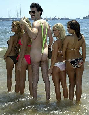 Borat on the beach in Cannes wearing only a smile and his thong swimsuit